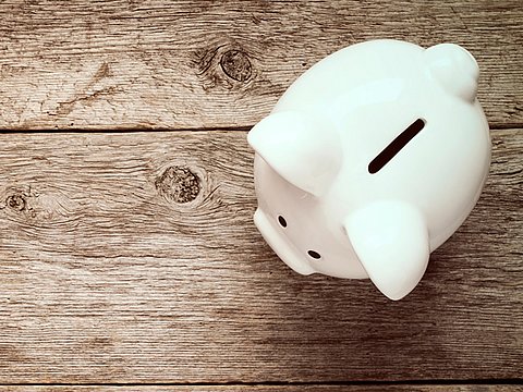 Piggy bank on an empty wooden desk